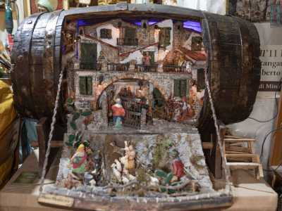 Sopra vi sono appoggiate decine di presepi ricostruiti dentro caffettiere, botti...